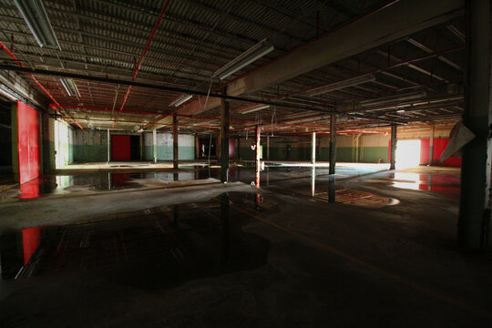 Standing Water Reflecting Red Walls and Ceiling of Abandoned Warehouse Interior