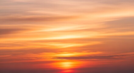 Fototapeta premium Vibrant sunset sky with fiery orange and soft pink clouds creating a beautiful gradient