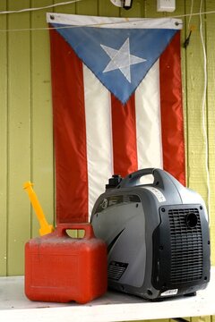 A gas tank and a generator on a table in front of the flag of Puerto Rico.