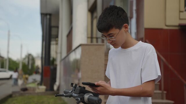 Young user renting public electric scooter in city street. Technology and mobility concept, real people, authentic urban lifestyle. Wireless technology and modern public transport concept.