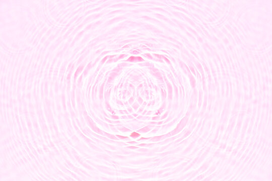 Pink water bubbles on the surface ripples. Defocus blurred transparent pink colored clear calm water surface texture with splash and bubbles. Water waves with shining pattern texture background