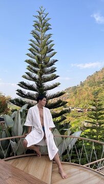 Handsome male model relaxing happily by the outdoor swimming pool in summer.