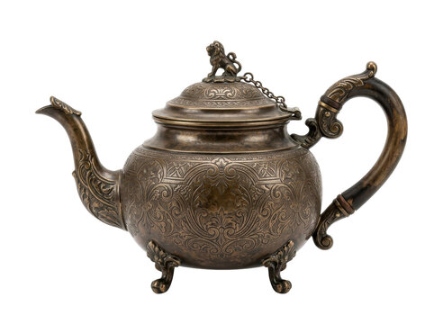 An ornate antique bronze teapot with intricate engravings and a chain-hinged lid sits isolated on a white background.