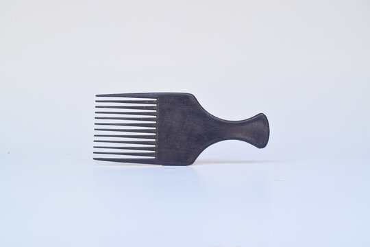 Minimalist Afro comb product presentation on white backdrop showing grooming usage, studio lighting and a clean composition