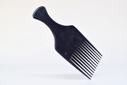 Elegant afro comb product styling textured hair with soft shadows, bright background and isolated composition