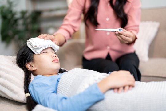 Mother Checking Her Sick Daughter's Temperature with Digital Thermometer