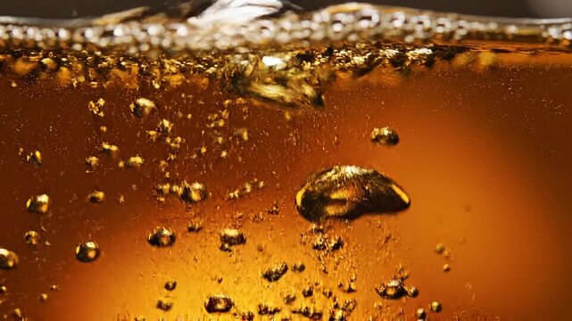 Close-up of fizzy brown beverage with bubbles.