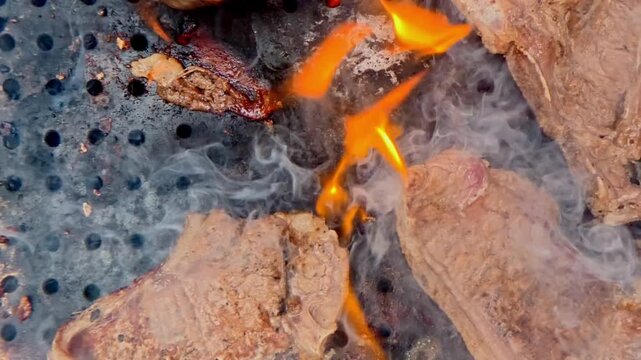 Smoking pork chops grilling on a fiery barbecue