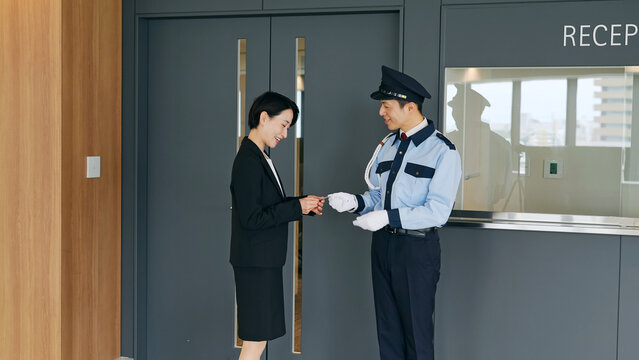 女性スタッフのIDをチェックする男性警備員