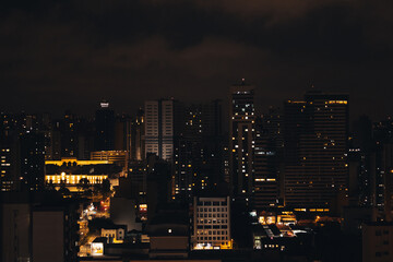 Fototapeta premium Paisagem Urbana Noturna de Curitiba com Edifício Iluminado em Destaque