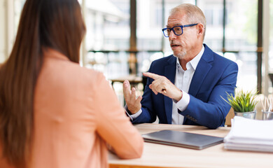 Senior businessman mentoring young professional woman in office © David