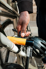 Fototapeta premium Man's hand locking bicycle with u-lock for security