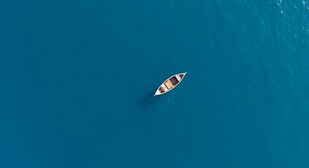 Fototapeta premium Aerial Top View of a Rowboat on Deep Blue Ocean Water