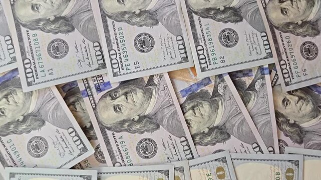Moving to stack of US american dollar bills, close-up background. 100 of cash money banknotes. Finance and investment concept. Currency exchange of one hundred usd