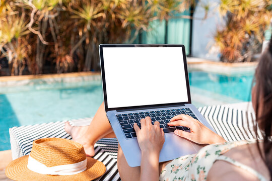Young woman freelancer traveler working online using laptop while traveling for summer vacation, Workation and digital nomad concept