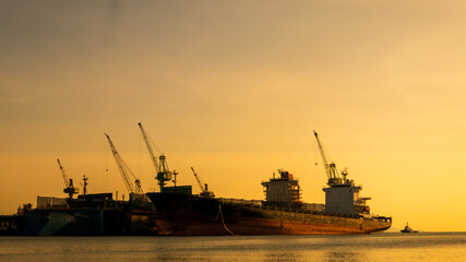 Fototapeta premium Logistics seascape shipping portal. Logistic shipping quay boat Engineering crane depot at logistic export terminal control. . Logistic shipping quay boat in twilight sky night Engineering crane