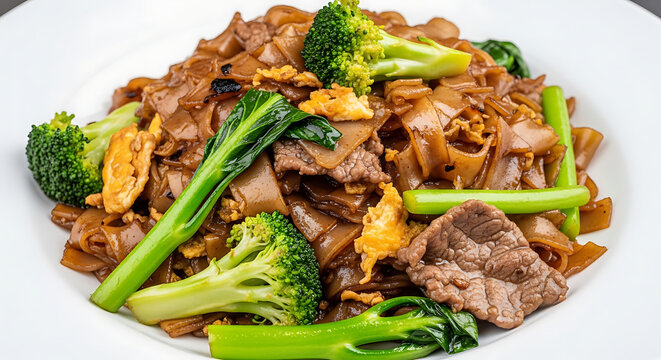Delicious pad see ew dish with beef broccoli noodles on white plate