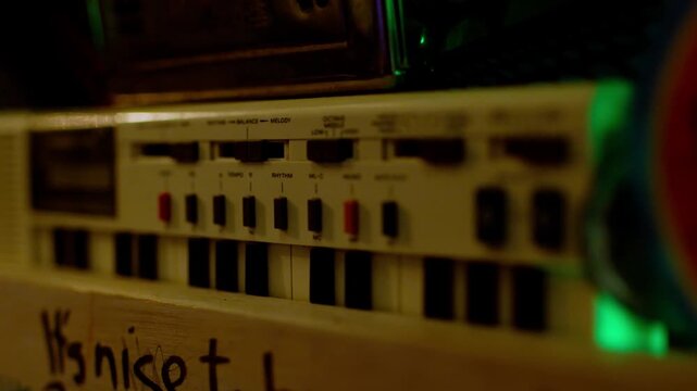 Primer plano de teclado electr&oacute;nico vintage con iluminaci&oacute;n ambiental verde y est&eacute;tica retro de los a&ntilde;os 80.