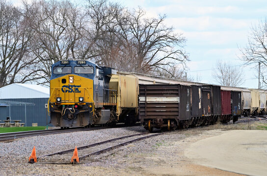 A CSX Transportation locomotive works as a rear-train distributed power unit (DPU) on an eastbound unit train along Burlington Northern Santa Fe tracks through a north central Illinois community.