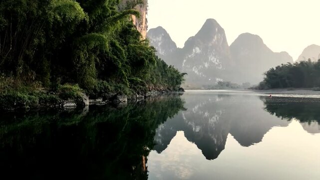 A serene view of the li river with lush green foliage and karst mountains in guilin at sunrise