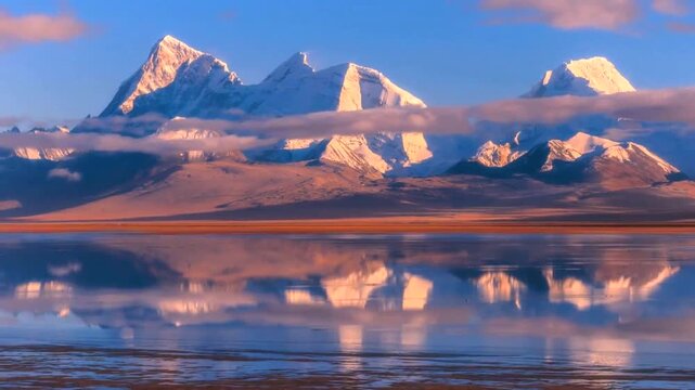 A serene landscape of snow capped mountain peaks reflected in the calm waters of a high altitude lake