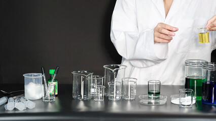 Fototapeta premium Scientist in White Lab Coat Holding Beaker with Yellow Liquid in Laboratory