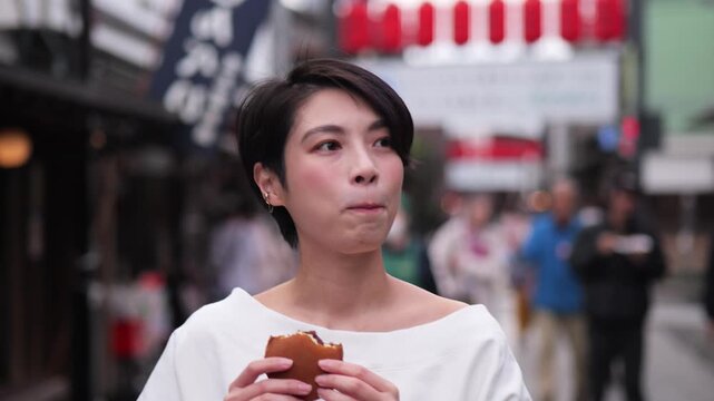 観光地で食べ歩きをする女性のフォローショット