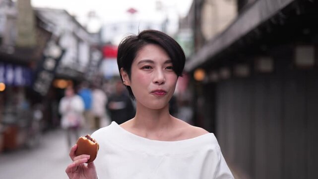 観光地で食べ歩きをする女性のフォローショット