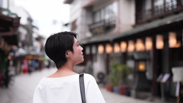 伝統的な観光地を見物する女性の後ろ姿のフォローショット