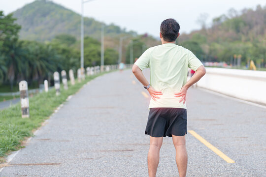Adult male runner with back and waist ache due to piriformis syndrome and low back pain. man having muscle injury or spinal compression during running. Sports medicine and healthcare concept