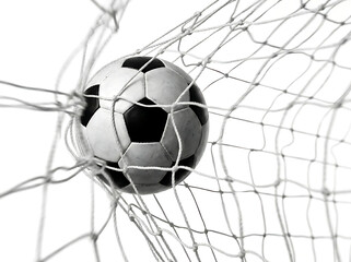 Naklejka premium Soccer ball in goal net on white background
