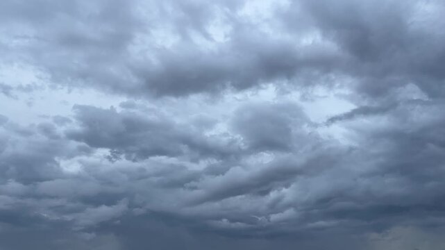 The dark sky with heavy clouds converging and a violent storm before the rain. Bad or moody weather sky and environment. carbon dioxide emissions, greenhouse effect, global warming, climate change.