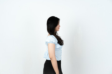 Profile portrait of young Asian woman looking forward against a clean white background © Sino Images Studio