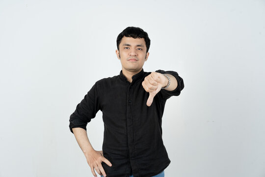 Young man making thumbs down sign to express dissatisfaction with the service