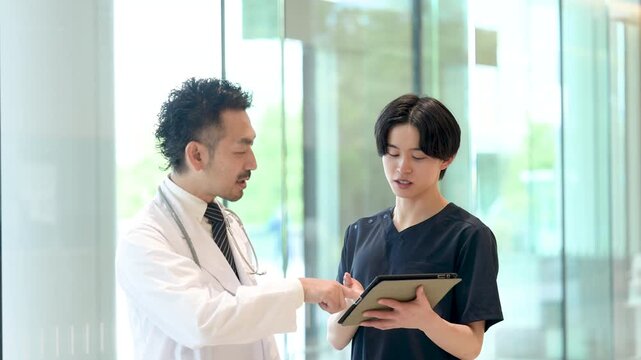 タブレットを見ながら指導や申し送りする医師と新人ドクターや看護師医療現場のDXとチーム連携イメージ動画