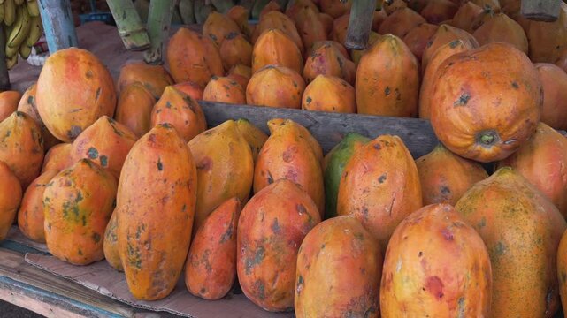 Pile of fresh orange papayas on display for sale at local street market