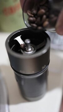 pouring coffee beans into the grinder