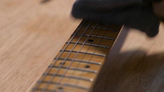 Close up shot the hand using microfiber fabric to clean the electric guitar