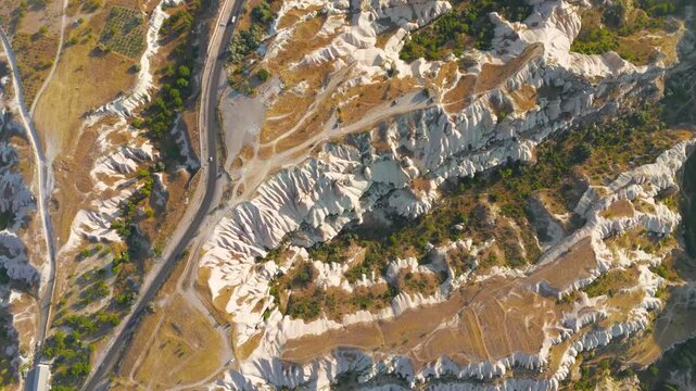 Uchisar, Nevsehir, Turkey. Top down aerial view of Cappadocia plateau showing intricate network of asphalt roads, dirt tracks and walking paths through valleys with trees.. Aerial View, HEAD OVER SHO
