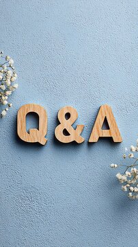 Q&A wooden letters on a blue textured background with flowers