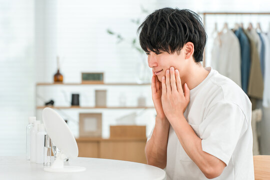 A young Asian man is delighted that his skin problems have been resolved and alleviated through skincare.