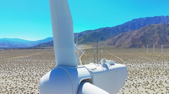 Aerial drone close up of non working wind turbine in Palm Springs California desert with mountain backdrop