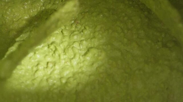 Close view of creamy avocado texture being blended into smooth paste in production