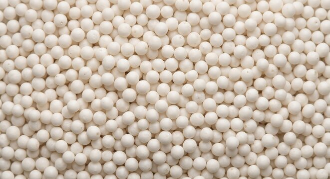 Macro shot of small white tapioca pearls arranged in a dense, uniform pattern creating a smooth, spherical textured background for food or abstract use
