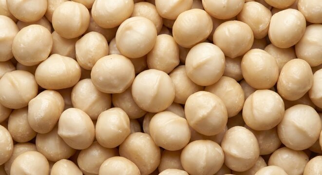 Abundant pile of whole, shelled macadamia nuts with smooth, creamy white surfaces and subtle indentations creating a natural, wholesome food texture