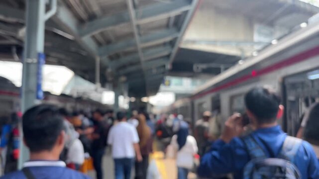 Morning scene at a train station in Jakarta, during rush hour, people are rushing to and from work. The video is blurry.