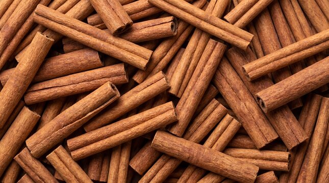 A vibrant overhead shot of numerous dried cinnamon sticks a popular aromatic spice with a warm reddish-brown hue and a rough textured surface creating a visually rich and inviting composition of