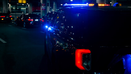 Police vehicle with siren on city street. Police patrol during night traffic conditions. Police car shows authority and control. Police provide safety and security. © Volodymyr