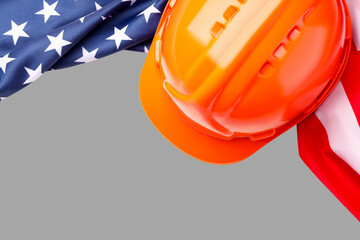 Naklejka premium Hard hat rests near American flag showing Labor Day spirit
