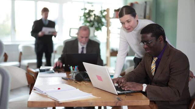 Woman manager helping to man during working at laptop in office. High quality 4k footage